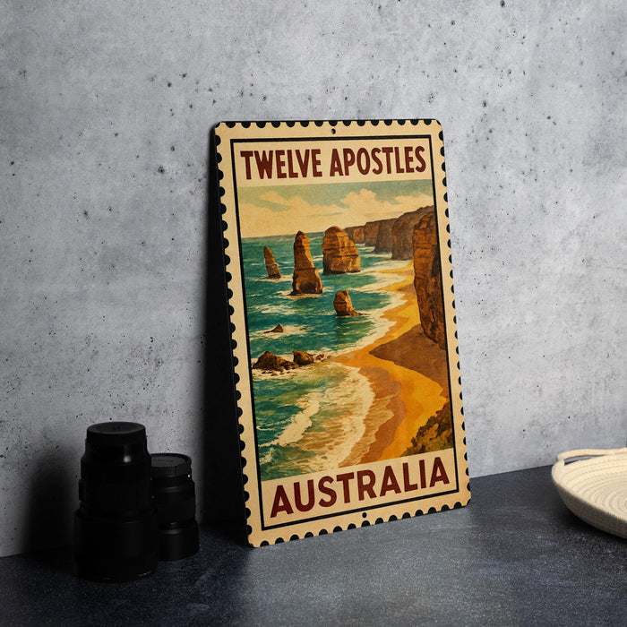 A vintage-style poster of the Twelve Apostles, a famous limestone stacks in Australia, is displayed on a wall next to some black camera lenses.