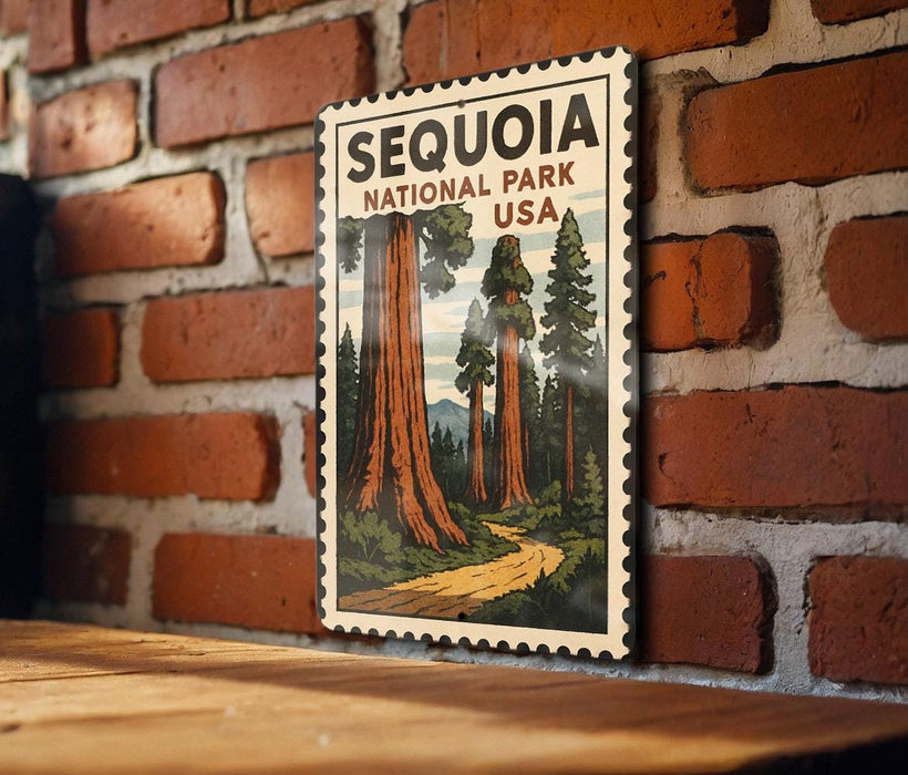 A framed vintage postage stamp depicting the Sequoia National Park in the United States, with a wooden table and a brick wall in the background.