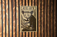a wooden wall with a framed illustration of a cat, which appears to be a type of longhorn cat.