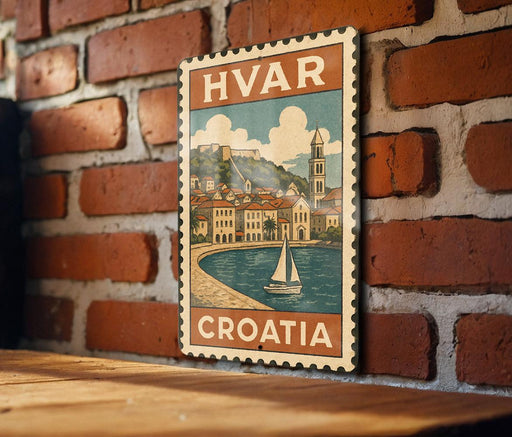 A vintage-style metal sign with the text "HVAR CROATIA" is displayed on a brick wall, featuring an illustration of a coastal town with a sailboat.