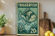 A framed poster of a fish, likely a triggerfish, is displayed on a shelf next to a wooden cutting board and some lemons.