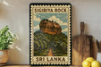 A framed poster of Sigiriya Rock, a famous landmark in Sri Lanka, is displayed on a wall next to a wooden cutting board and some potted plants.