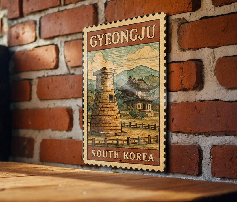 A vintage postage stamp depicting a traditional Korean temple, with the text "GYEONGJU SOUTH KOREA" printed on it, is displayed on a brick wall.