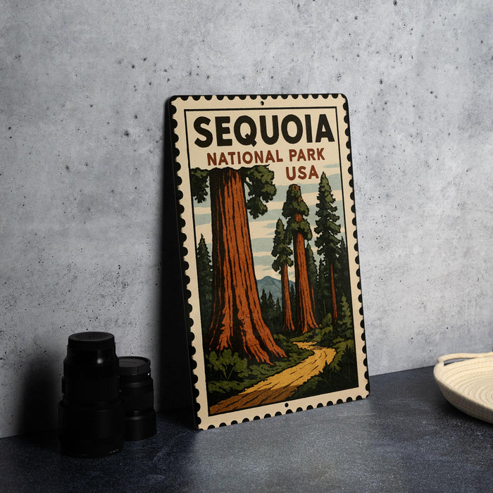 A vintage-style metal sign depicting the Sequoia National Park in the USA, featuring a scenic illustration of towering sequoia trees and a winding path.