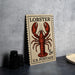 A U.S. postage stamp featuring a lobster illustration, placed on a table next to some black camera lenses.
