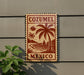 A wooden sign with a tropical beach scene and palm trees, mounted on a wall.