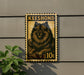 A decorative metal stamp featuring a dog illustration, mounted on a wall next to a plant.