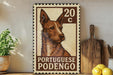 A Portuguese Podego dog stamp is displayed on a wooden surface, with a potted plant and kitchen utensils visible in the background.