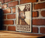 A 20 Portuguese podengo postage stamp is displayed on a brick wall.