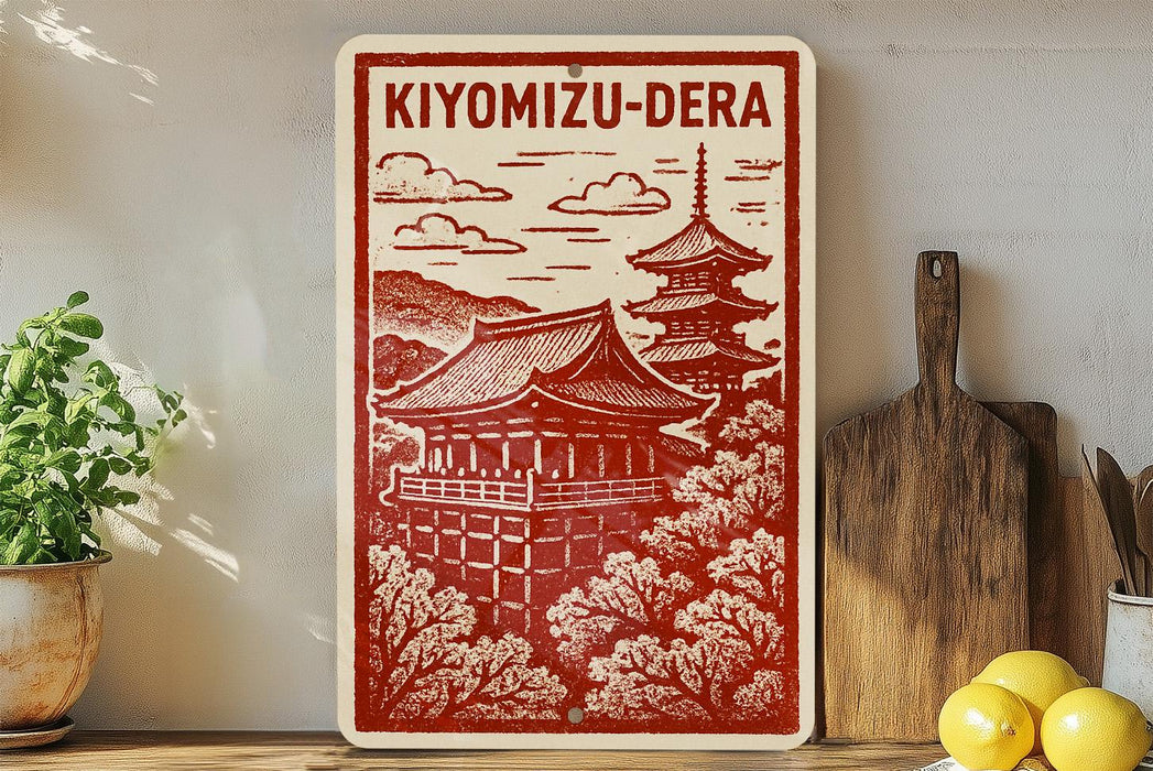 A red and white sign with an illustration of a traditional Japanese temple, surrounded by trees, is displayed on a shelf next to a wooden cutting board and some potted plants.