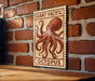 a large, detailed illustration of an octopus on a wooden surface, mounted on a brick wall.
