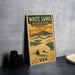 A vintage-style poster of White Sands National Park, featuring a desert landscape with mountains and a cactus in the foreground.