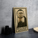 a framed illustration of a white-faced capuchin monkey on a wooden surface.