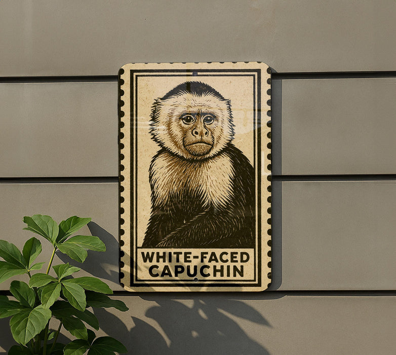 a white-faced capuchin monkey depicted on a sign, which is mounted on a wall.