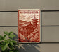 A sign with a red and white design depicting a traditional Japanese temple surrounded by trees, mounted on a gray wall.