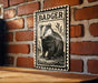 A metal sign featuring a black and white illustration of a badger is mounted on a brick wall.