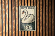 A vintage-style postage stamp featuring a swan swimming in a body of water, with the text "MUTE SWAN" and "10c" printed on it.