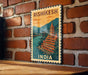 A vintage-style poster of the Rishikesh Temple in India, featuring a colorful illustration of the temple and a river.