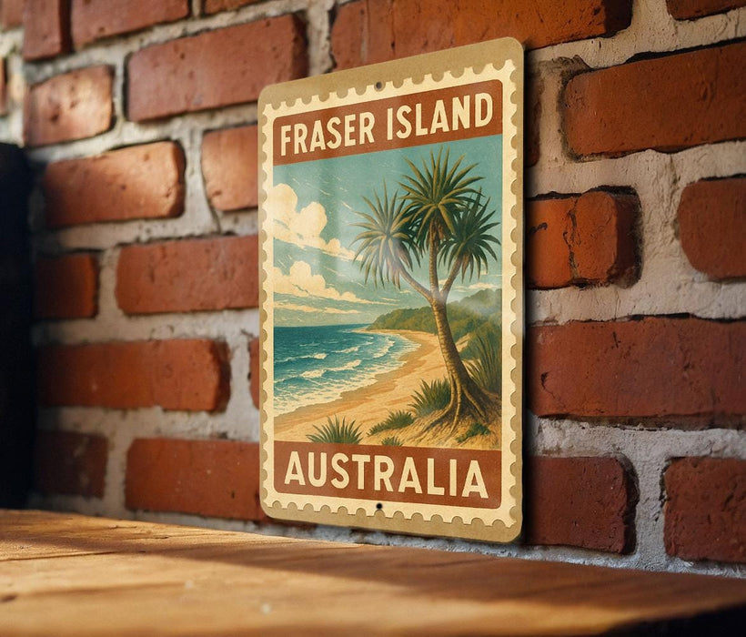 A vintage-style metal sign with the text "FRASER ISLAND AUSTRALIA" and a tropical beach scene, mounted on a brick wall.
