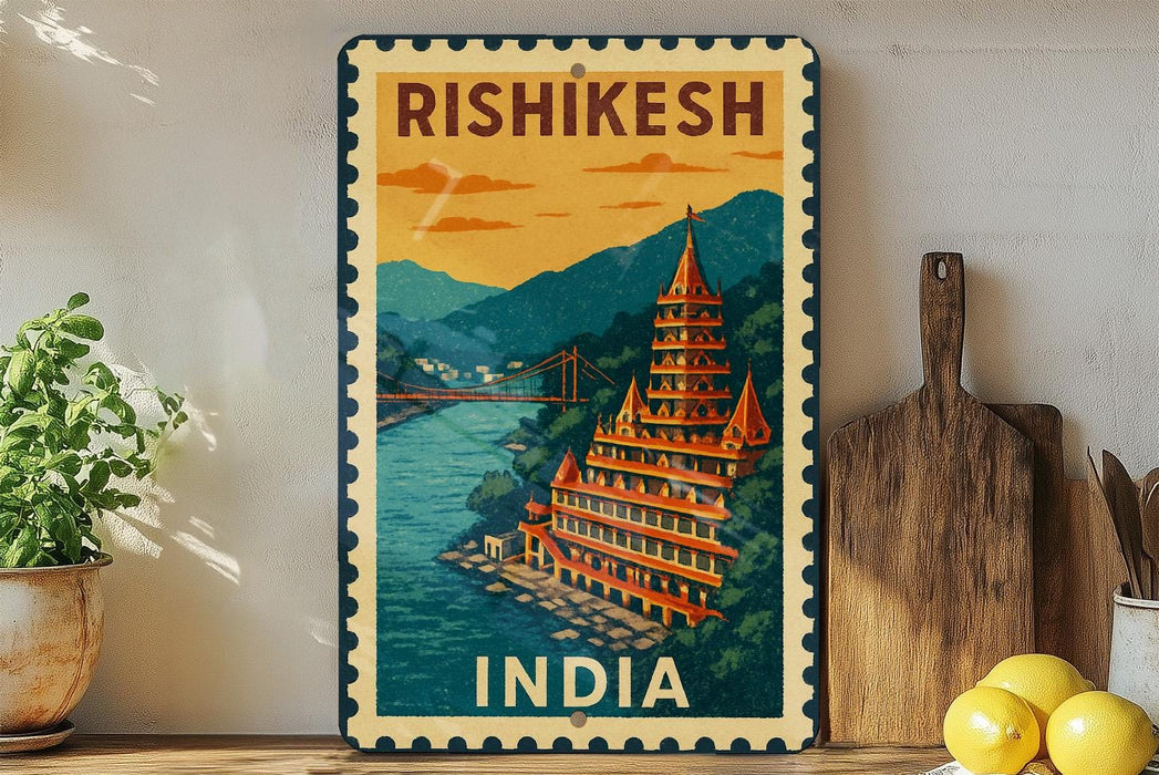 A vintage-style metal sign with a colorful illustration of a temple and a river, along with the text "RISHIKESH INDIA" on it, is displayed on a shelf next to a potted plant and a wooden cutting board.