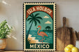 A vintage-style metal sign with a flamingo and palm tree illustration, advertising "Isla Holbox Mexico", is displayed on a shelf next to a wooden cutting board and a potted plant.