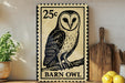A vintage-style 25c postage stamp featuring a barn owl, placed on a wooden surface next to a wooden cutting board and some lemons.