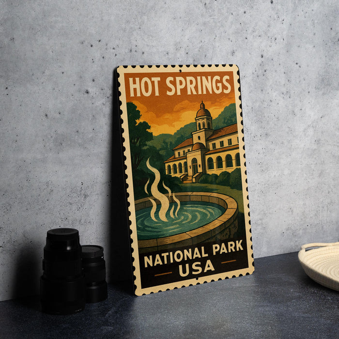 A vintage-style metal stamp depicting Hot Springs National Park in the USA, featuring a building and a fountain.