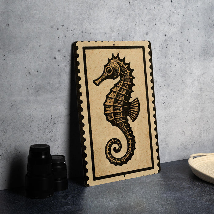 a decorative metal sign with a black and white illustration of a seahorse on a beige background.