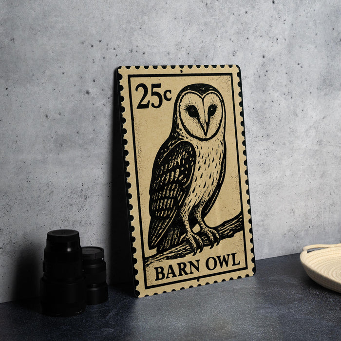 A 25c postage stamp featuring an illustration of a barn owl, placed on a table next to some black camera lenses.