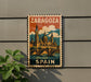 A vintage-style metal sign with the text "ZARAGOZA SPAIN" displayed on it, featuring an illustration of a cityscape with a bridge and domes.