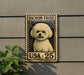 A small white poodle is depicted on a postage stamp-like sign, mounted on a wall.