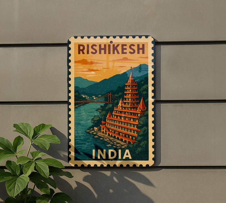 A vintage-style postage stamp depicting a temple in Rishikesh, India, with a bridge and mountains in the background.