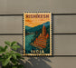 A vintage-style postage stamp depicting a temple in Rishikesh, India, with a bridge and mountains in the background.