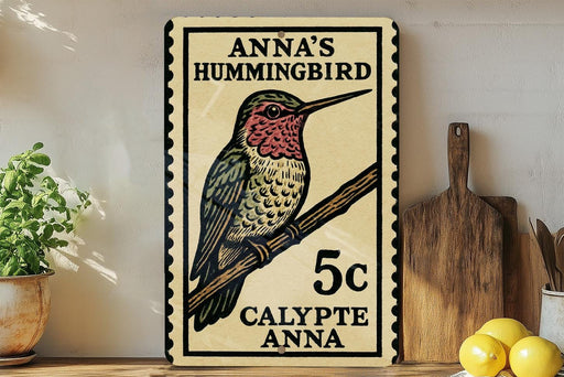 A framed print of a hummingbird, with text indicating it is a postage stamp for Anna's hummingbird.