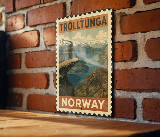 A vintage-style poster of Trolltunga, a famous mountain range in Norway, is displayed on a brick wall.