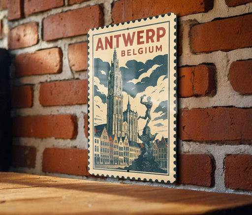 A vintage-style poster of Antwerp, Belgium, featuring a clock tower and a statue, is displayed on a brick wall.