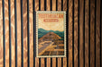 A vintage-style poster of Teotihuacan, the ancient city in Mexico, is displayed on a wooden wall.