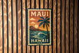 A vintage-style metal sign with the text "MAUI HAWAII USA" and a palm tree illustration, mounted on a wooden wall.