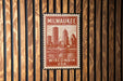 A Milwaukee, Wisconsin postage stamp is displayed on a wooden wall.