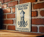 a sign with a squid illustration and the text "Common Squid" on a brick wall.