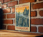 A vintage-style postage stamp depicting a mountainous landscape with the text "TSINGY DE BEMARHA MADAGASCAR" printed on it, hanging on a brick wall.