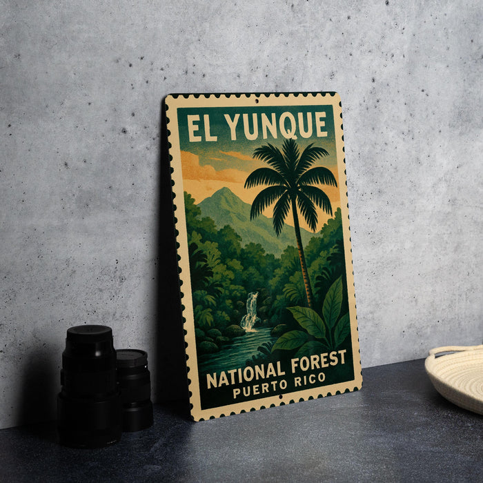 A vintage-style metal sign for the National Forest in Puerto Rico, featuring a palm tree and a waterfall, is displayed on a gray concrete surface.