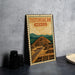 A metal sign with the text "TEOTIHUACAN MEXICO" and an illustration of an ancient Mayan pyramid, placed on a gray countertop next to some black camera lenses.