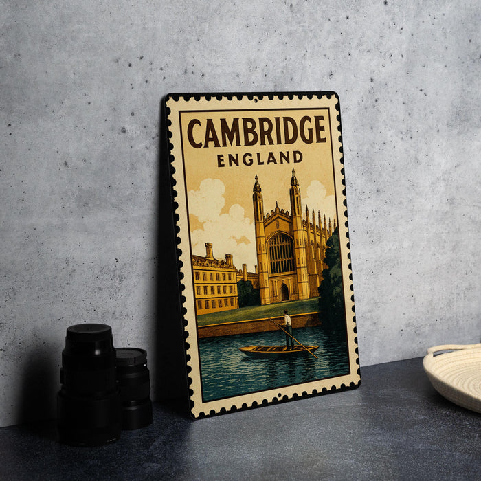 A metal stamp depicting the iconic architecture of Cambridge, England, with a person rowing a boat on the River Thames in the foreground.