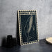 a framed artwork of a humpback whale, which is placed on a table next to some black camera lenses.