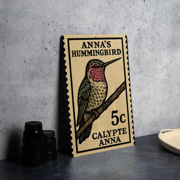 A wooden postcard featuring a colorful illustration of a hummingbird, with text indicating it is a postage stamp for Anna's hummingbird.