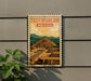 A vintage-style poster of Teotihuacan, the ancient city in Mexico, is displayed on a wall.