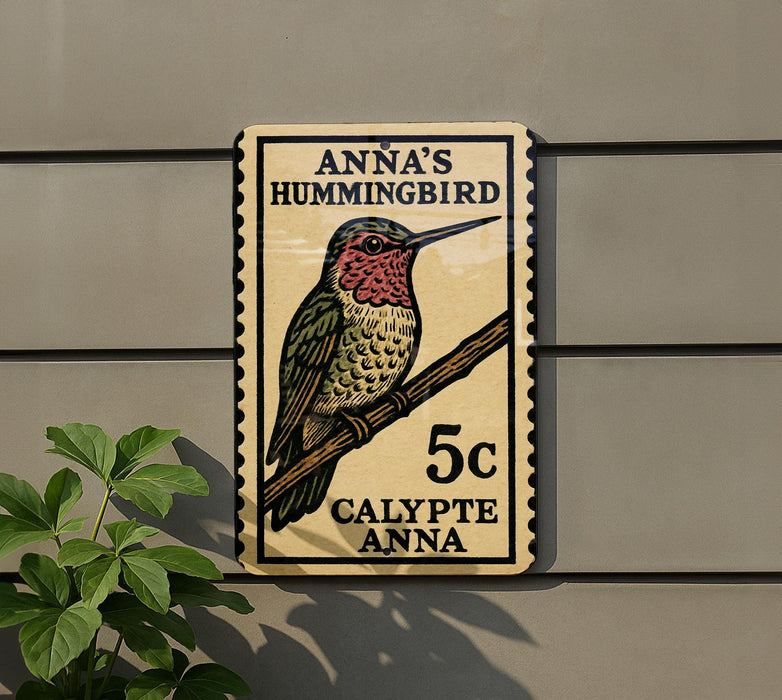 A wooden sign with a hummingbird illustration and text, mounted on a wall next to a plant.