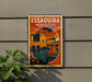 A vintage-style metal sign with the text "ESSAOUIRA MOROCCO" displayed on a wall, featuring an illustration of a castle and a sailboat.