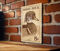 A wooden sign featuring a wood duck illustration is mounted on a brick wall.